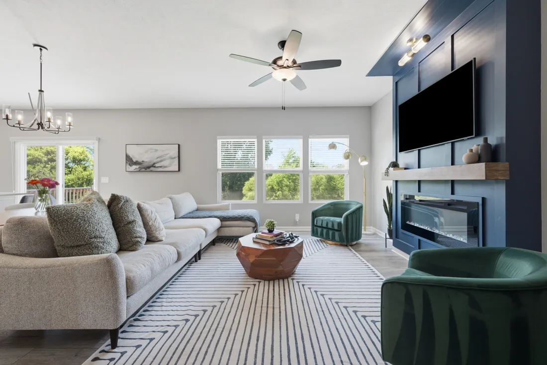 A modern living room with a blue accent wall and fireplace